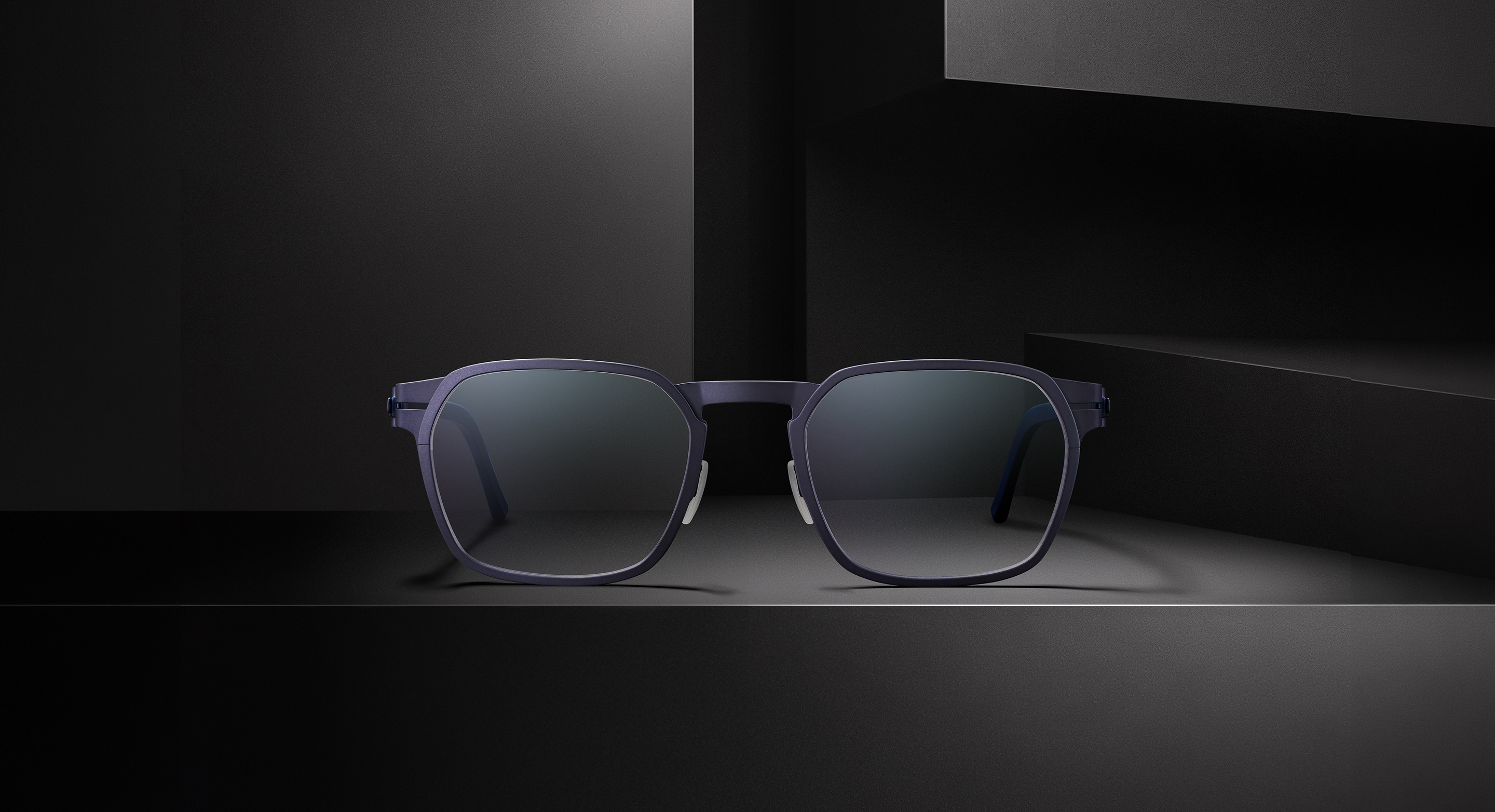 OVVO Optics Ti2 Expanded Atlas titanium sunglasses front view on a dark architectural set