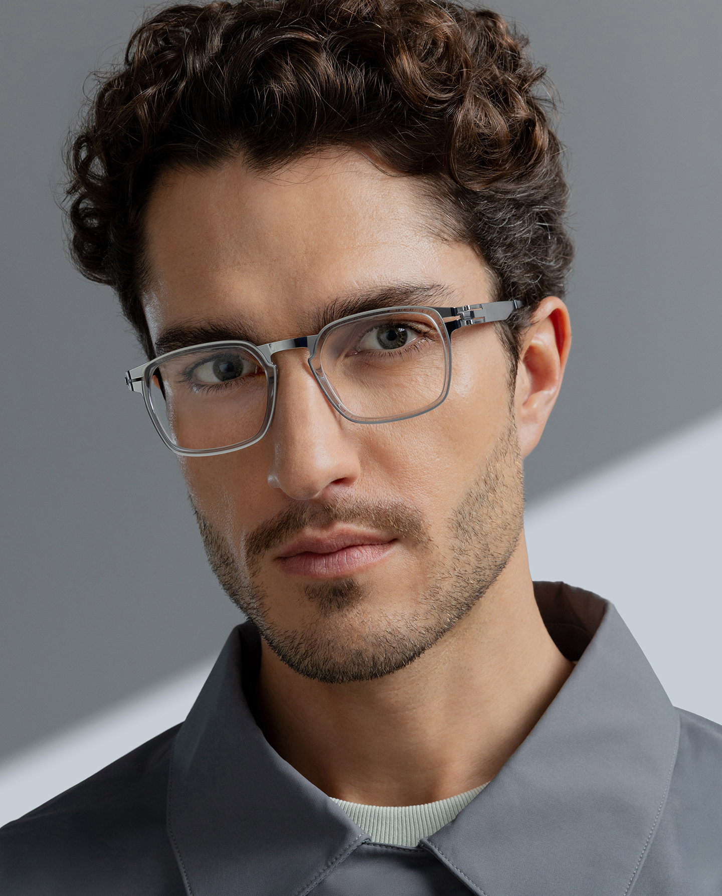Man in a gray jacket wearing OVVO Optics DUO Anderson clear hexagonal eyeglasses with a silver metal browline