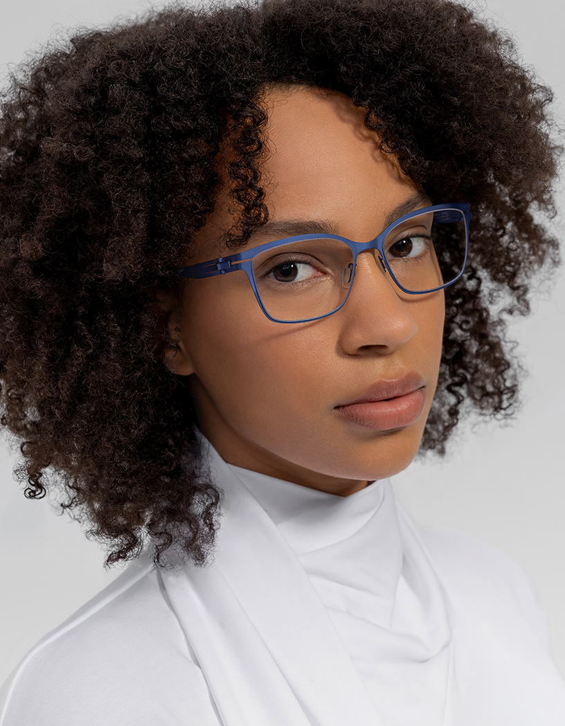 OVVO Optics close-up portrait of a woman in blue optical glasses with a white top, from the spring collection